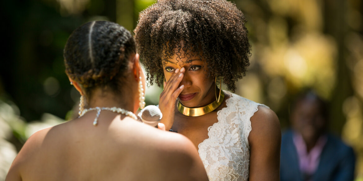 Emotional wedding ceremony with two women exchanging vows.